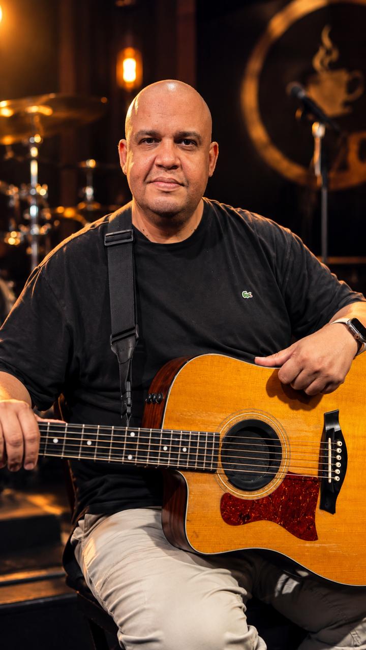 Alexandre Ramos, da DIM Produções, com violão no palco